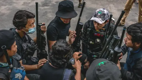 Getty Images Anti-coup protesters hold improvised weapons during a protest in Yangon on April 03, 2021 in Yangon, Myanmar