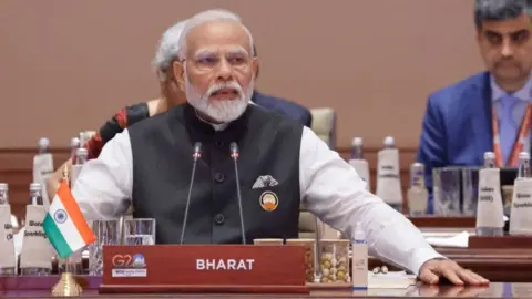 Getty Images India's Prime Minister Narendra Modi (C) speaks during the first session of the G20 Leaders' Summit at the Bharat Mandapam in New Delhi on September 9, 2023. (Photo by Ludovic MARIN / POOL / AFP) (Photo by LUDOVIC MARIN/POOL/AFP via Getty Images)