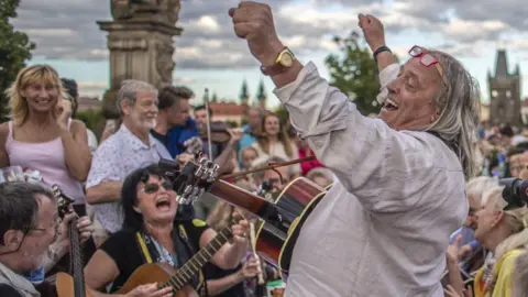 EPA Musicians perform as diners sit at a gigantic table