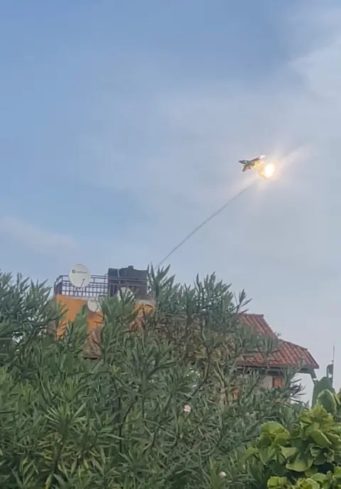 @JEANPAULBISHWE7 via Reuters There is a flash in the sky as a projectile is fired at a plane.