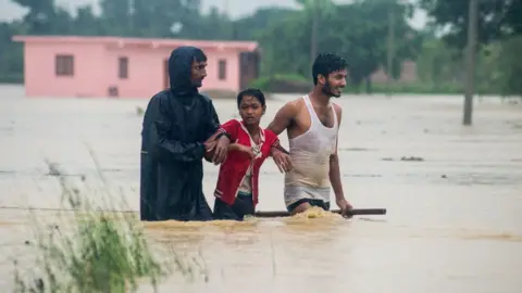 AFP Nepali residents wade along a flood area at Birgunj Parsa district, some 200km south of Kathmandu,