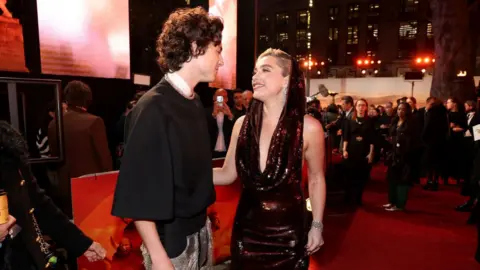 Getty Images Chalamet and Pugh have a chat on the red carpet