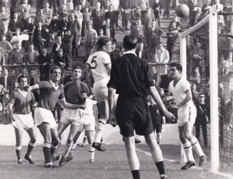 Judith Gates/Larry Ellis Players in a penalty area jostle for the ball