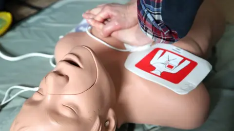 Getty Images Aaron learnt CPR on a doll thanks to training with the scouts and an NHS training day in Liverpool.