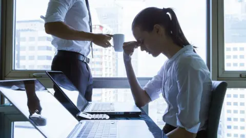 Getty Images Stressed woman in an office