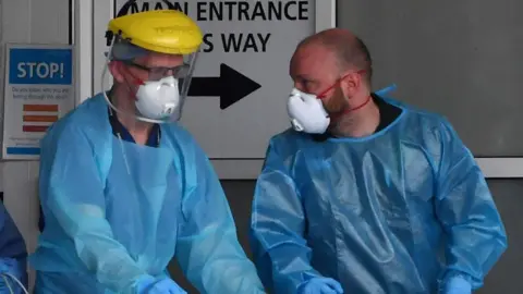 PAUL ELLIS/AFP Healthcare workers in PPE