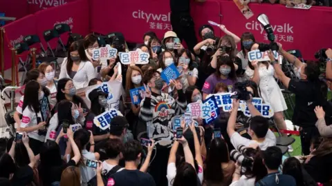 Getty Images Edan Lui of boy band Mirror is surrounded by fans