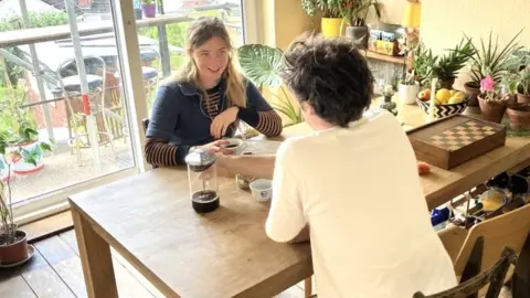 Alex Bygrave and Meriwether Lewis chatting at their kitchen table