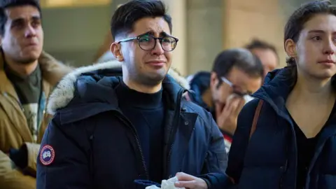 AFP A man weeps during a service at Western University for four graduate students killed in the plane crash