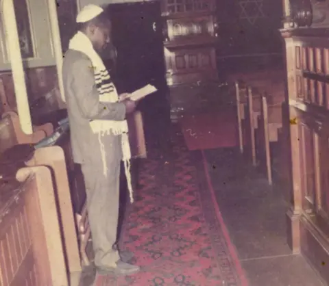 Michael Lomotey Man worshipping in a synagogue