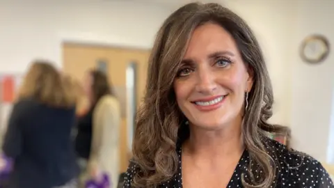 CEO Claire Marshall looking at the camera wearing a polka dot top.