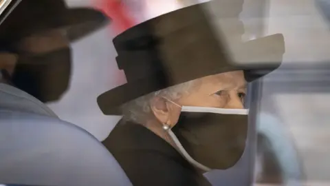 PA Media The Queen dressed in black with a black face mask