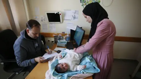 Getty Images Palestinian patients gather at the UNRWA health center to receive medicines as the Israeli attacks continue in Deir Al-Balah, Gaza on January 21, 2024.