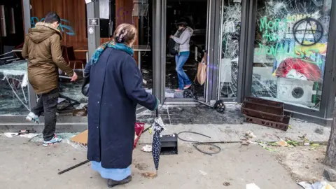 EPA Pedestrians look at a destroyed McDonald's fast food restaurant after a demonstration of workers from the private and public sectors as well as labour unions on the occasion of the annual May Day