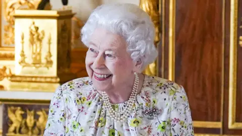 The Queen smiles as she arrives to view a display of artefacts from British craftwork company
