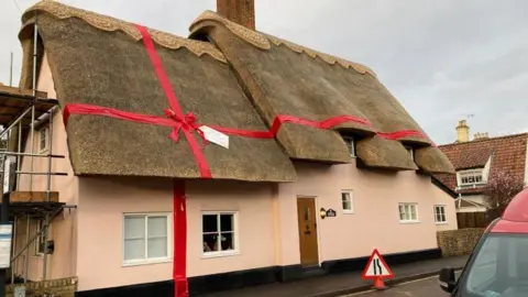 Thatched cottage tied with ribbon