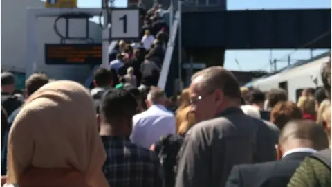 Valentina Montoya  Commuters on a railway station platform