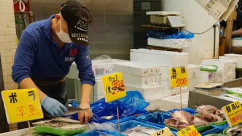 A man works at a seafood at a seafood store in Tokyo, Japan, 25 September 2023.