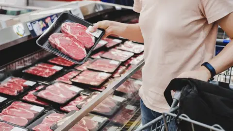 Getty Images Mulher compra carne bovina em supermercado