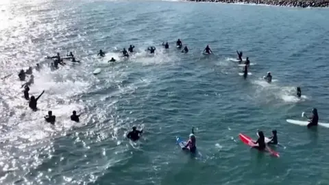 Surfers forming a circle in the sea