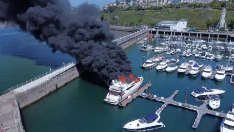 Reuters Thick black smoke rises from a fire on a yacht at Torquay harbour