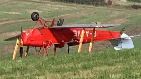 G-AJVE plane lying upside down in a field