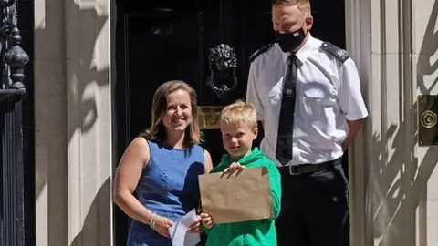 PA Media Ilmarie Braun with son, Thomas, with a letter outside number 10 Downing Street