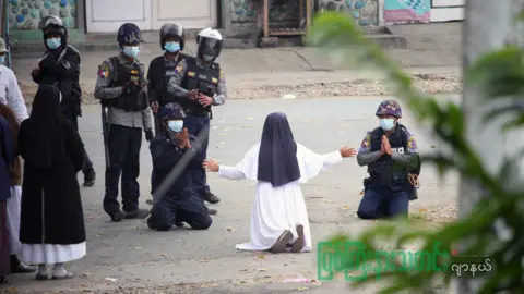 Myitkyinar News Journal via Reuters Sister Ann Rose Nu Tawng kneeling before police in March 2021