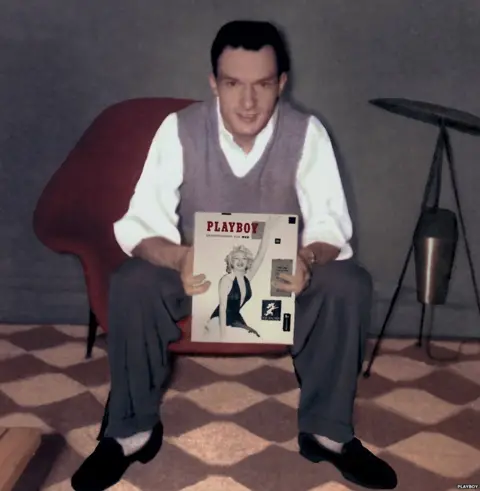 Playboy Hugh Hefner holding the first cover of Playboy magazine