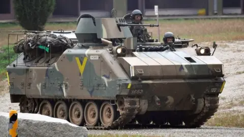 AFP South Korean soldiers ride on an armoured vehicle during a South Korea-US combined arms collective training exercise at the US army's Rodriguez shooting range in Pocheon, about 70km north-east of Seoul (19 September 2017)