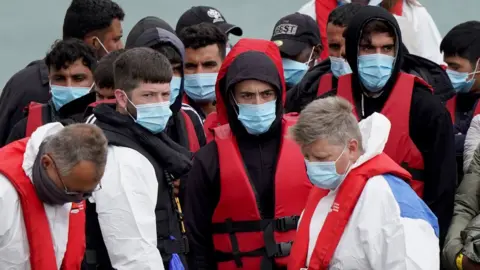 PA Media A group of people thought to be asylum seekers brought into Dover by Border Force
