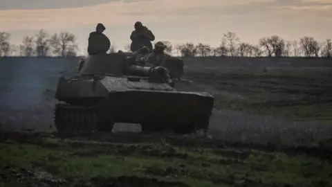 Reuters Ukrainian servicemen ride a self-propelled howitzer, amid Russia's attack on Ukraine, on a frontline in Donetsk region