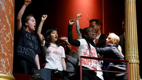 Getty Images French protestors voiced their support for abortion rights from a balcony during a debate on a draft law on the constitutionalisation of the right to abortion at the Senate in Paris