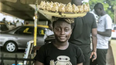 BBC Street seller with a tray of groundnuts on her head