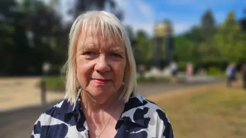 Charnwood borough councillor Anne Gray smiles at the camera she is wearing a blue and white shirt.