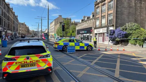 Two police cars block a tram track