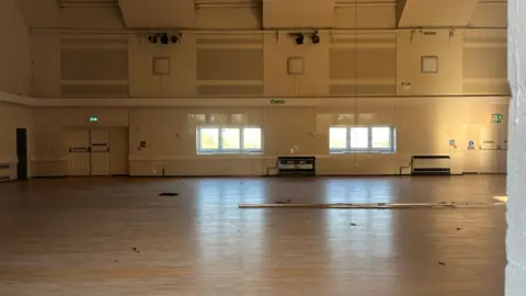 Tom Jackson/BBC An empty room inside the centre with some items on the floor. It looks clean but disused. 