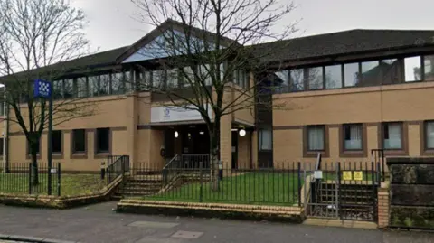 a google view of the exterior view of a sandstone police station building. 