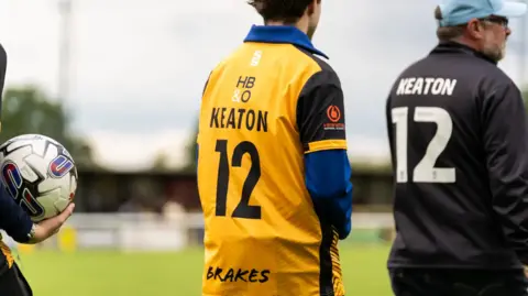 Cameron Murray Two people on a football pitch with the name Keaton and number 12 on the back of their shirts