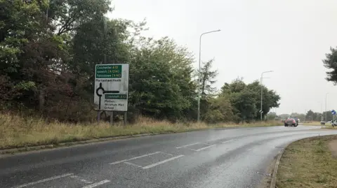 Vikki Irwin/BBC Road sign with directions to Colchester and Lowestoft and the A12.