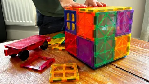 University of Southampton a child's hands playing with a multi-coloured toy box made with magnets