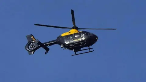 Eddie Mitchell The police helicopter in flight, against a backdrop of a perfectly blue sky.