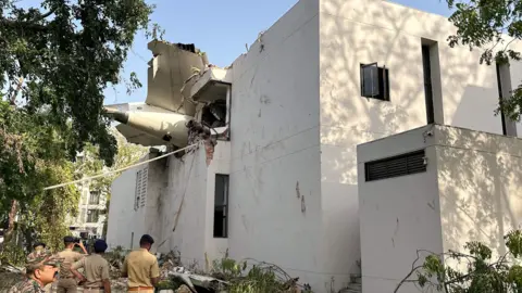 Reuters A tail of an Air India Boeing 787 Dreamliner plane that crashed is seen stuck on a building after the incident in Ahmedabad, India, June 12, 2025. REUTERS/Amit Dave