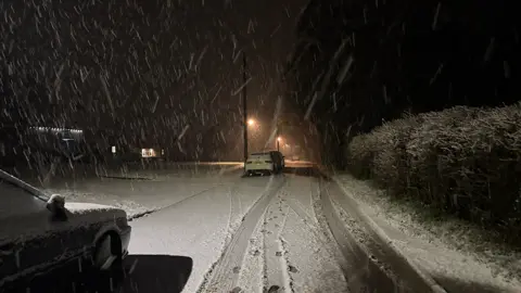 A snowy street with cars