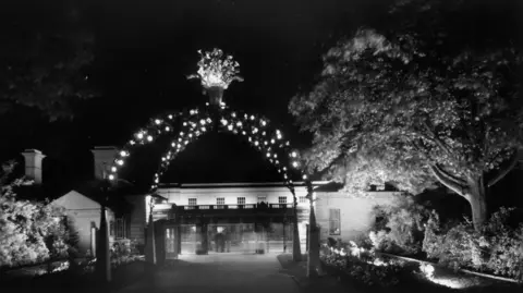 Leamington Spa Art Gallery and Museum A black and white photo of an arch of lights in Jephson Gardens in 1950s