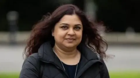 Gareth Everett Huw Agency Tanya Nasir looking at the camera, she is wearing a black coat and t-shirt and her brown hair is down