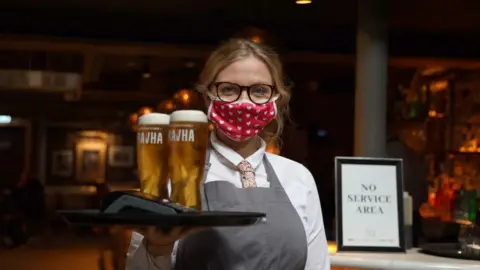 Pacemaker A waitress wearing a mask carried a tray of beers