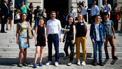 Getty Images Greta Thunberg and other youth climate activists stand outside France's parliament