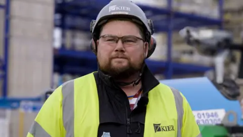 Carl Walmsley at work at Sellafield is wearing a hi-vis jacket yellow jacket and hard hat.