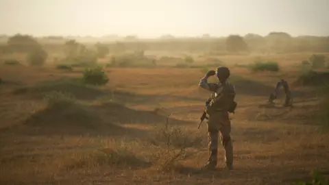 AFP A French soldier monitors a rural area during an operation in northern Burkina Faso, along the border with Mali and Niger, on 10 November 2019